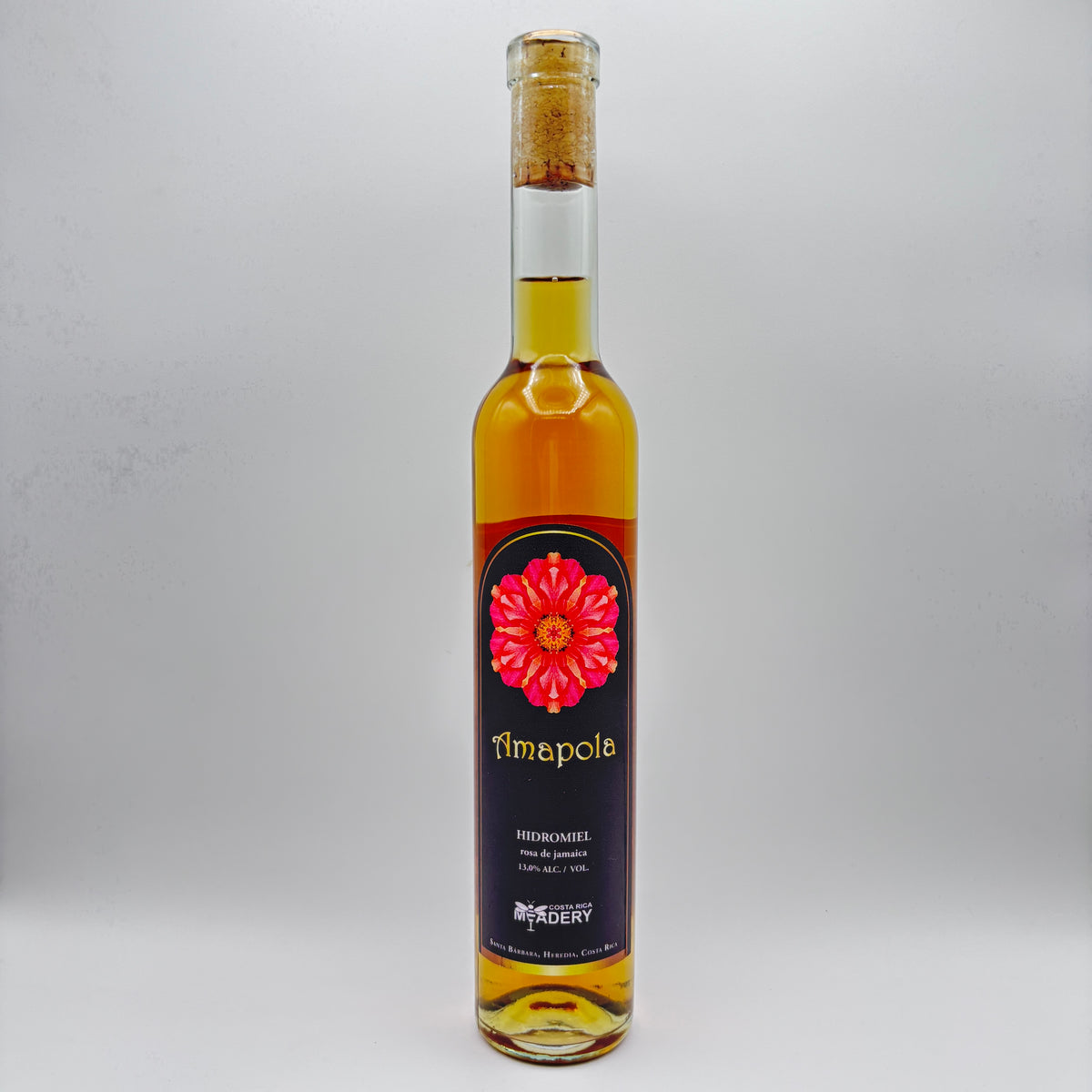 Botella de vidrio de Hidromiel Amapola (Flor de Jamaica) con corcho y etiqueta negra con flor roja de Costa Rica Meadery.