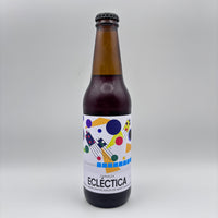 Botella de Cerveza Ecléctica con limón kaffir y malta de maíz, mostrando una etiqueta blanca con figuras geométricas de colores sobre un fondo neutro.