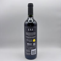 Vista trasera de la botella de hidromiel Exe mostrando la contraetiqueta con detalles del producto, sello de Medalla de Oro y código de barras sobre un fondo neutro.
