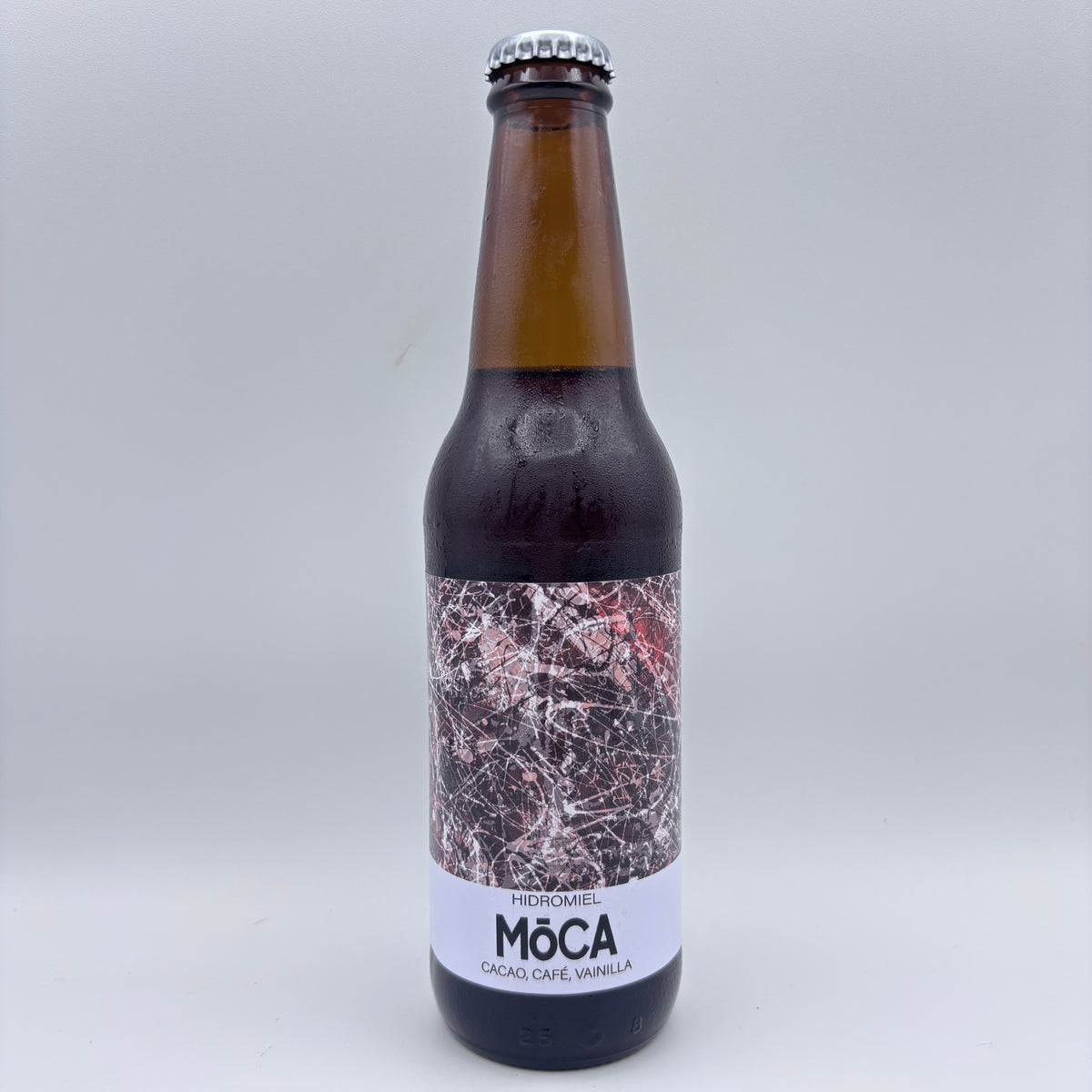 Botella de hidromiel Möca elaborado con cacao, café y vainilla, con una etiqueta con ilustración abstracta en tonos oscuros sobre un fondo neutro.