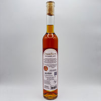 Vista trasera de la botella de hidromiel Passiflora Rum Barrel-Aged mostrando la contraetiqueta con la descripción del producto, sello de premiación, logo de Costa Rica Meadery y código de barras sobre un fondo neutro.